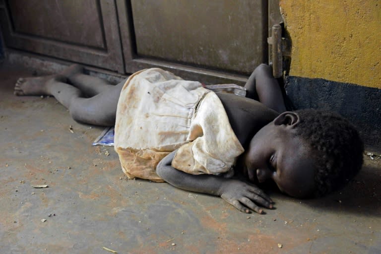 A child refugee sleeps on a floor after arriving in Uganda from South Sudan