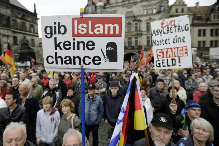 Supporters of the German right-wing movement PEGIDA hold up a poster reading "Give No Chance to Islam" as they attend a PEGIDA rally on June 1, 2015 in Dresden