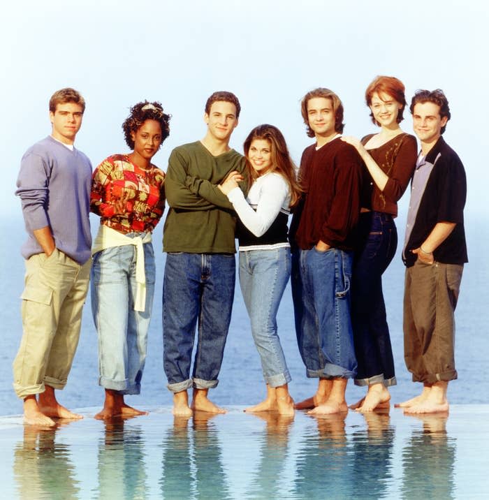 The cast of Boy Meets World poses barefoot while standing on water
