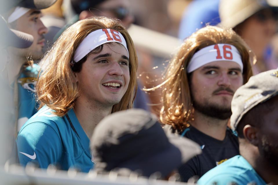 Jacksonville Jaguars fans watch an NFL football practice while wearing head pieces simulating Jacksonville Jaguars quarterback Trevor Lawrence, Saturday, July 31, 2021, in Jacksonville, Fla. (AP Photo/John Raoux)