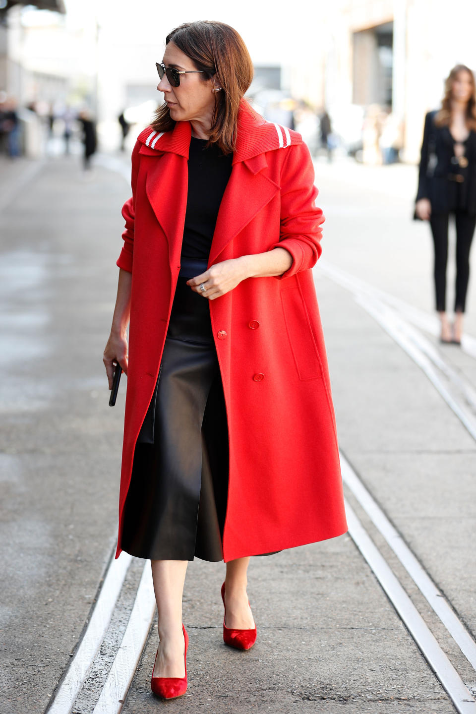 Vogue Australia Editor-in-Chief Edwina McCann wears a red coat and heels during Mercedes-Benz Fashion Week on May 14 in Sydney.