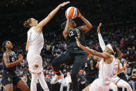 Las Vegas Aces guard Chelsea Gray (12) shoots between Phoenix Mercury guards Diana Taurasi (3) and Shey Peddy (5) during the second half of Game 5 of a WNBA basketball playoff series Friday, Oct. 8, 2021, in Las Vegas. (AP Photo/Chase Stevens)