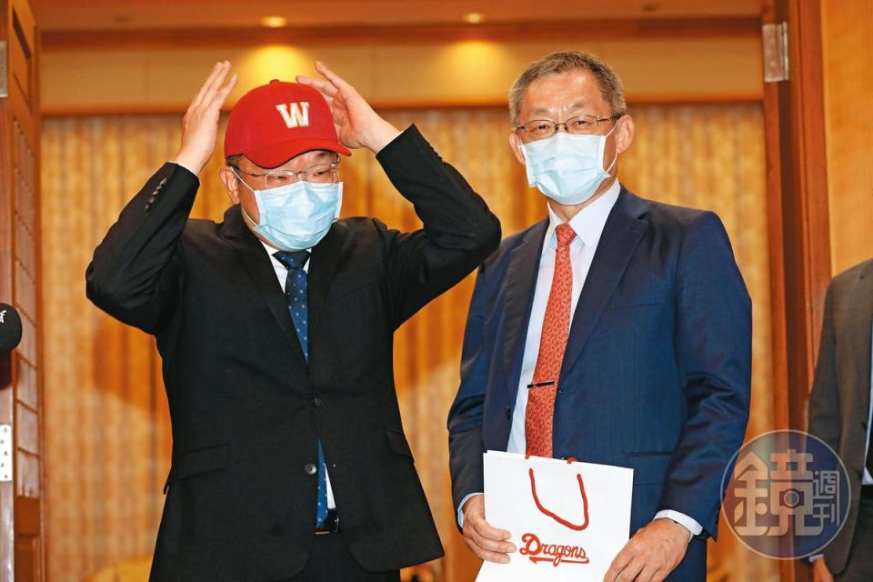 蔡其昌（左）去年12月24日允諾接下中職會長時，當場戴上味全龍隊帽送暖。右為味全龍球團董事長徐文芳。