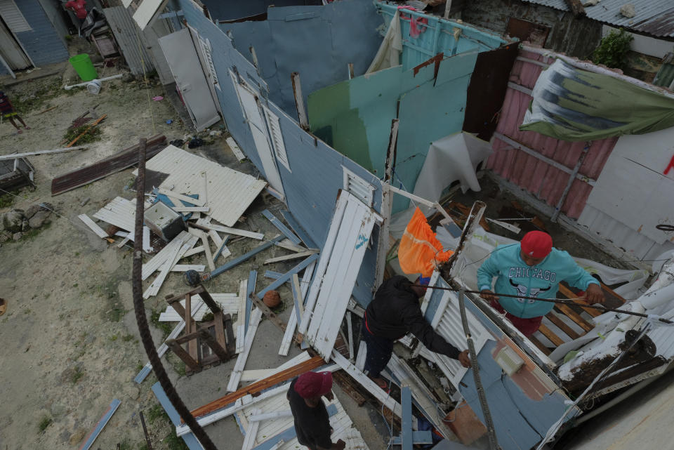 Residentes reemplazan el techo de una vivienda que fue arrancado por el huracán Fiona en Punta Cana, República Dominicana, el lunes 19 de septiembre de 2022. (AP Foto/Ricardo Hernandez)