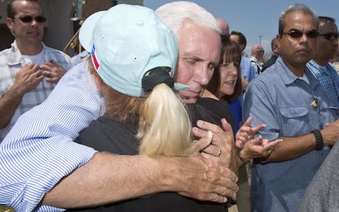 Mike Pence hugs a woman during a trip to survey the damage from Hurricane Harvey in Rockport, Texas - Credit: Bloomberg