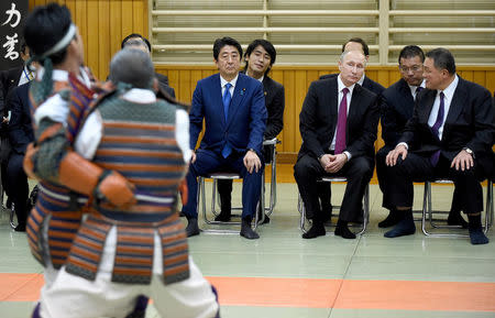 Russian President Vladimir Putin (2nd R) and Japanese Prime Minister Shinzo Abe (3rd R) look at a performance of ancient custom judo beside Vice Chairman of the All Japan Judo Federation Yasuhiro Yamashita (R) when they visit the Kodokan Judo Institute, the headquarters of the worldwide judo community, in Tokyo on December 16, 2016. REUTERS/Toru Yamanaka/Pool