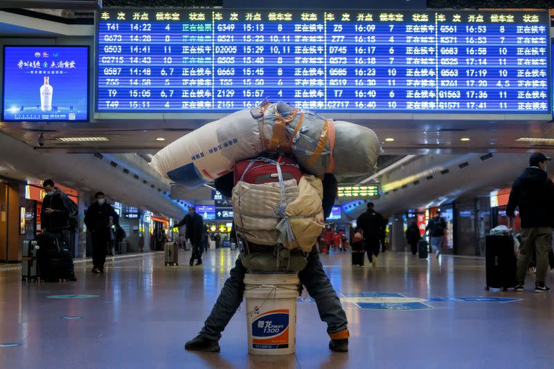 Traveller is seen with his belongings at a railway station in Beijing