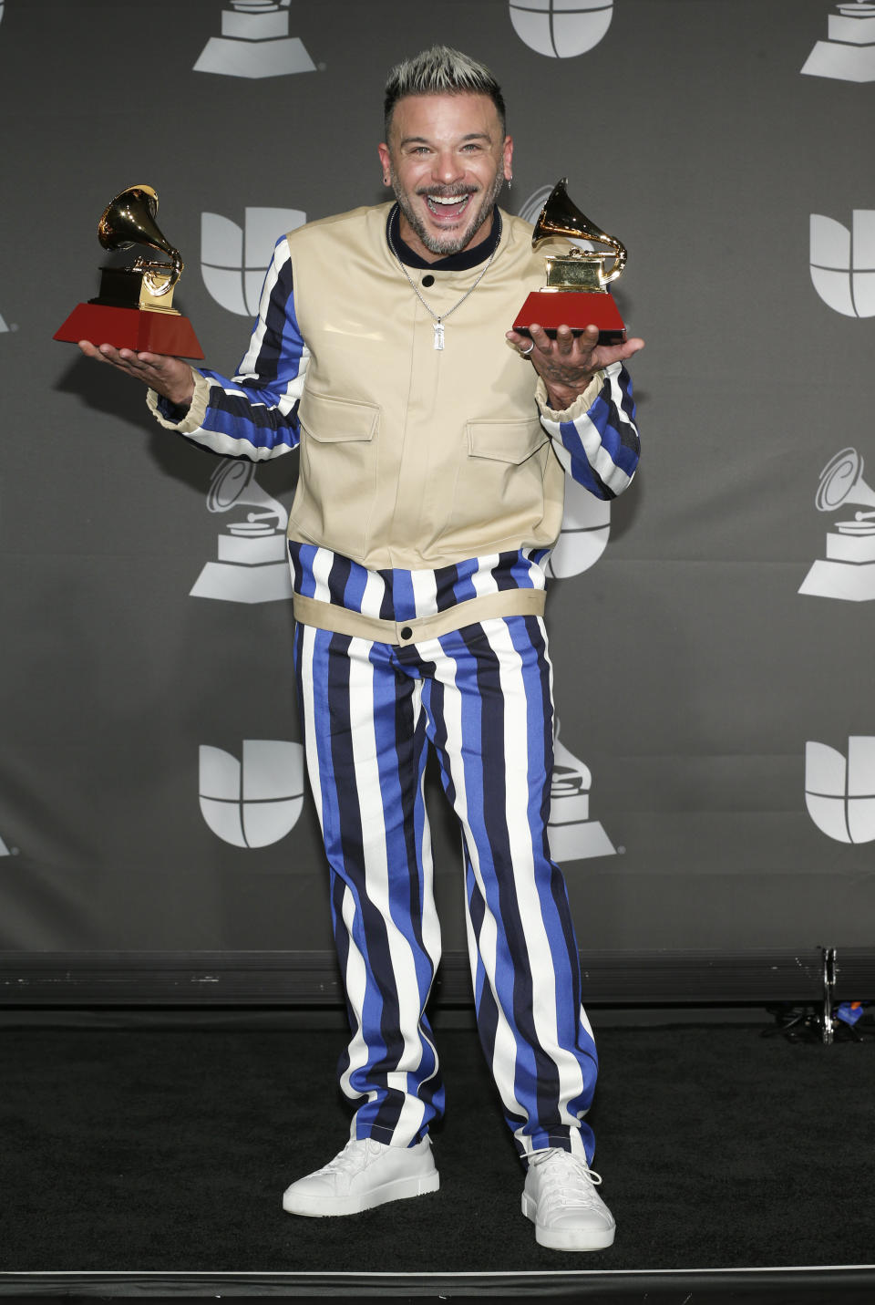 Pedro Capo poses in the press room with the awards for song of the year for "Calma" and best urban fusion/performance for "Calma (Remix)" at the 20th Latin Grammy Awards on Thursday, Nov. 14, 2019, at the MGM Grand Garden Arena in Las Vegas. (Photo by Eric Jamison/Invision/AP)