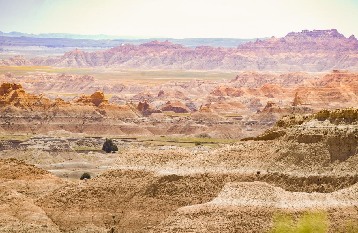 Sun shines on rock formations at Badlands National Park.