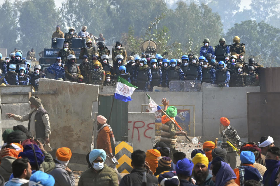 Protesting farmers face armed police personnel near Shambhu border that divides northern Punjab and Haryana states, almost 200 km (125 miles) from New Delhi, India, Wednesday, Feb.14, 2024. Protesting Indian farmers Wednesday clashed with police for a second consecutive day as tens of thousands of them tried to march to the capital New Delhi to demand guaranteed crop prices for their produce. (AP Photo/Rajesh Sachar)