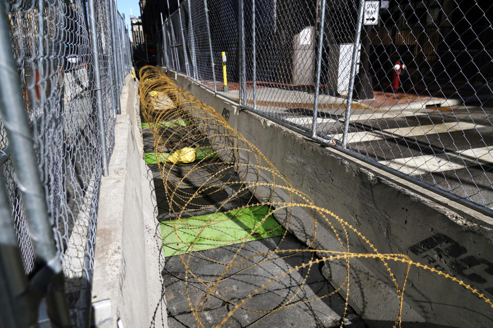 Concertina wire sits between fenced barriers outside the Hennepin County Government Center, Wednesday, Feb. 23, 2021, in Minneapolis, as part of security in preparation for the trial of former Minneapolis police officer Derek Chauvin. The trial is slated begin with jury selection on March 8. Chauvin is charged with murder the death of George Floyd during an arrest last May in Minneapolis. (AP Photo/Jim Mone)