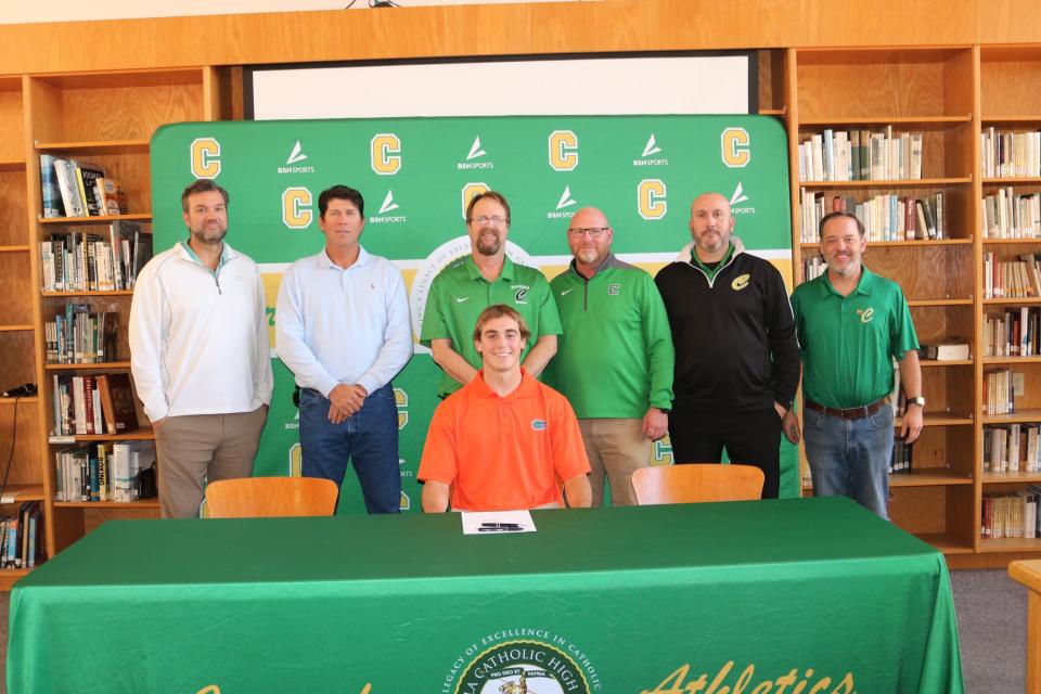 Pensacola Catholic's Brock Clayton (seated) poses for photos with Crusaders coaches after signing his letters of intent to play baseball collegiately at the University of Florida on Wednesday, Nov. 8, 2023 from Pensacola Catholic High School.