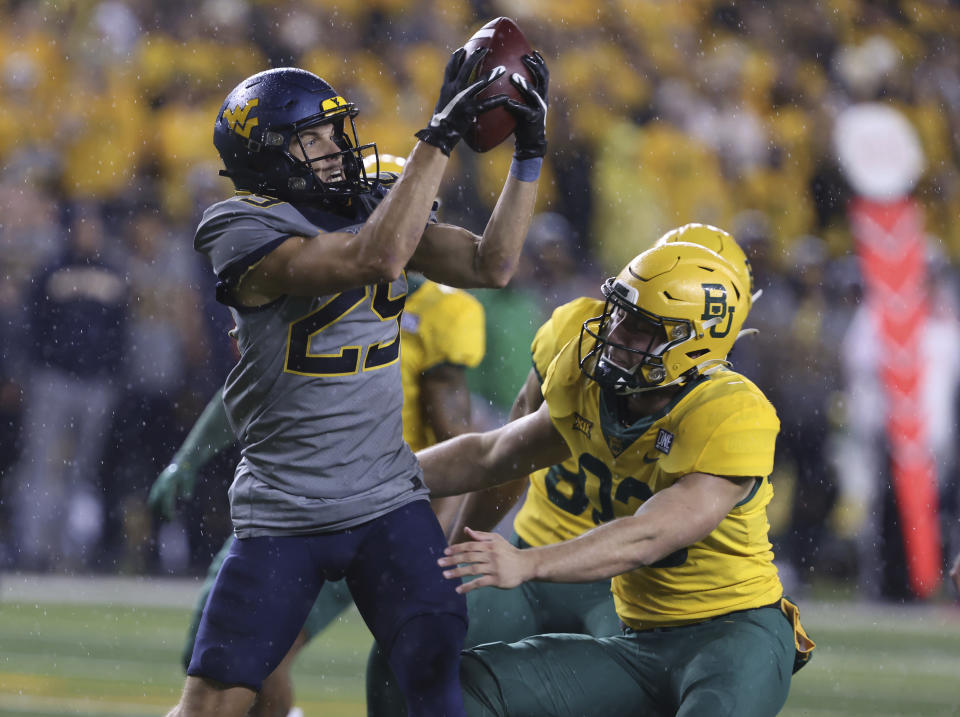 West Virginia wide receiver Preston Fox, left, pulls down a pass over Baylor defensive lineman D.K. Kalu, right, in the first half of an NCAA college football game, Saturday, Nov. 25, 2023, in Waco, Texas. (Rod Aydelotte/Waco Tribune-Herald, via AP)