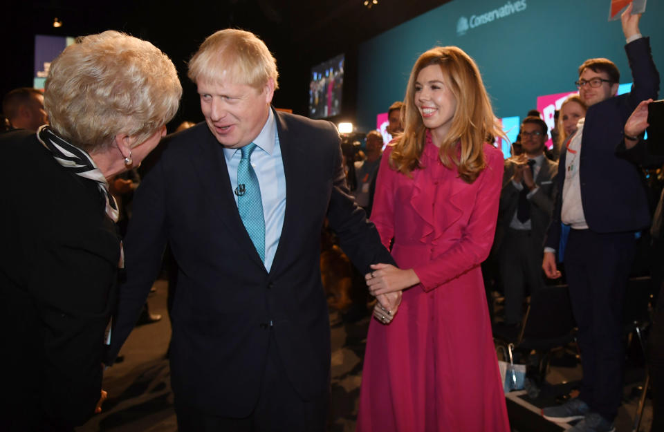 Britain's Prime Minister Boris Johnson leaves the stage after he finishes his Leader's speech and joins his girlfriend Carrie Symonds, during the Conservative Party Conference in Manchester, England, Wednesday, Oct. 2, 2019. (Jeremy Selwyn/Pool via AP)