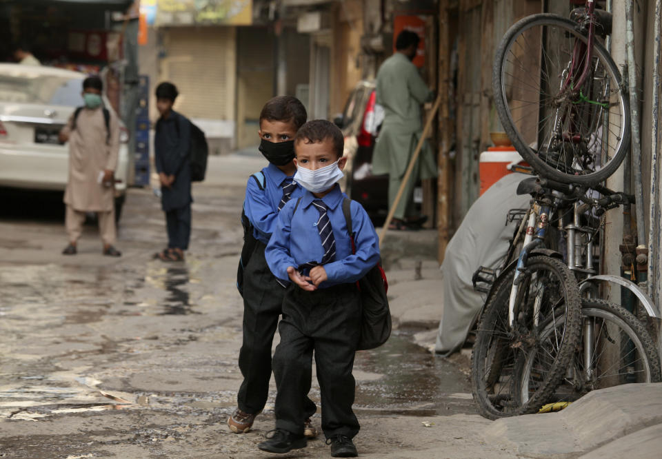 Students wear face masks to help prevent the spread of the coronavirus in Peshawar, Pakistan, Monday, June 7, 2021. Pakistani authorities reopened educational institutes following a steady decrease in deaths and infections from the coronavirus. (AP Photo/Muhammad Sajjad)