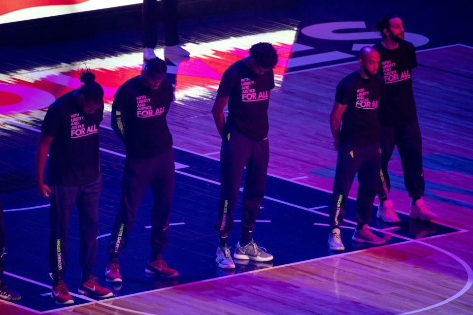 The Minnesota Timberwolves, pictured, and the Brooklyn Nets wear T-shirts that read "With liberty and justice for all"