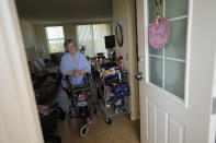 Joyce Loazia stands at the door of her apartment in a senior community in Coral Springs, Fla., Tuesday, Dec. 5, 2023. Loazia is among the first in the country to receive the robot ElliQ, whose creators, Intuition Robotics, and senior assistance officials say is the only device using artificial intelligence specifically designed to lessen the loneliness and isolation experienced by many older Americans. (AP Photo/Rebecca Blackwell)