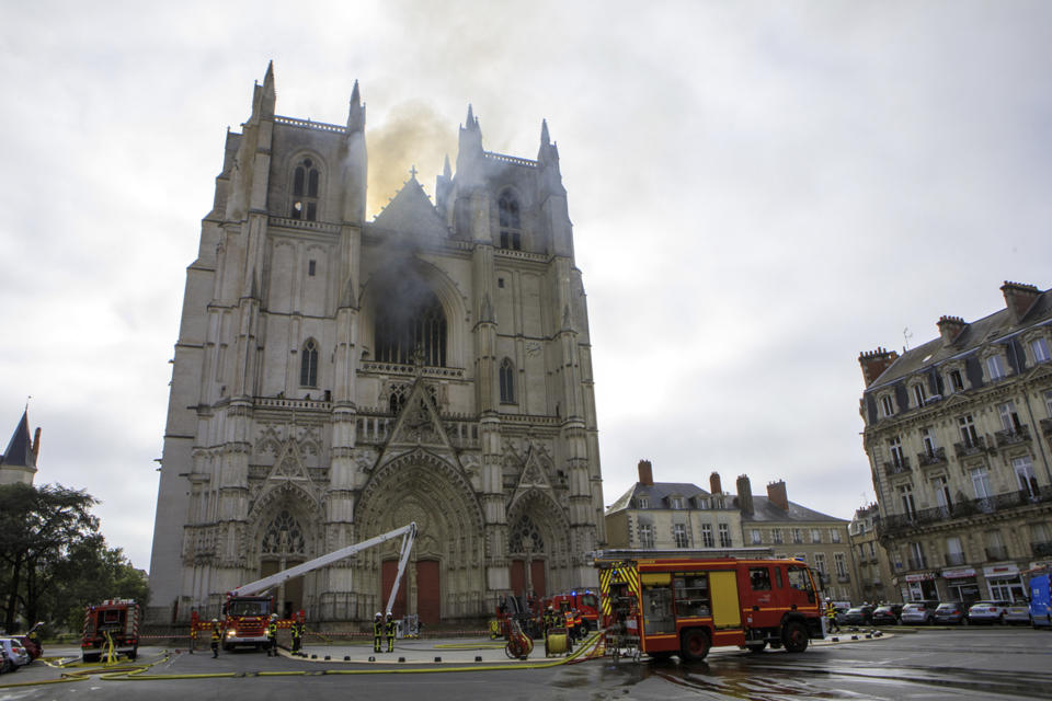 Fire fighters brigade work to extinguish the blaze at the Gothic St. Peter and St. Paul Cathedral, in Nantes, western France, Saturday, July 18, 2020. The fire broke, shattering stained glass windows and sending black smoke spewing from between its two towers of the 15th century, which also suffered a serious fire in 1972. The fire is bringing back memories of the devastating blaze in Notre Dame Cathedral in Paris last year that destroyed its roof and collapsed its spire and threatened to topple the medieval monument. (AP Photo/Laetitia Notarianni)