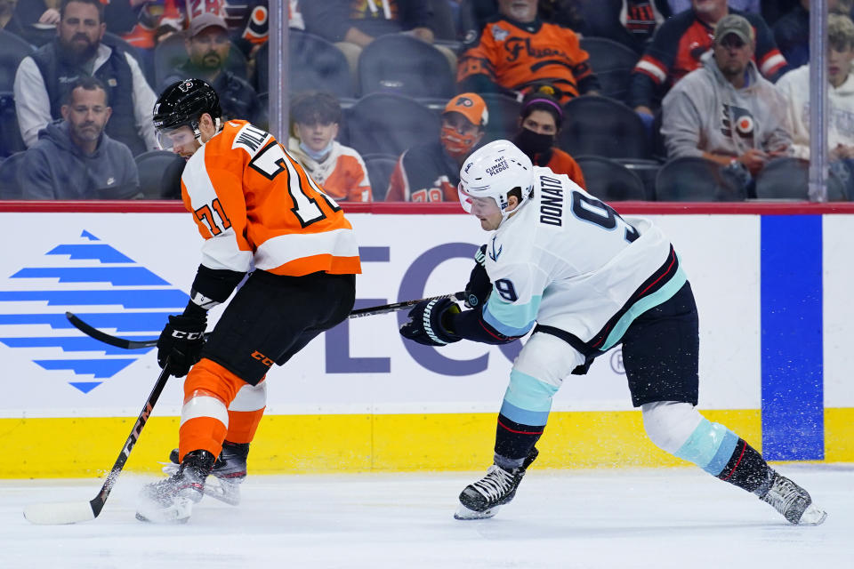 Philadelphia Flyers' Max Willman, left, and Seattle Kraken's Ryan Donato battle for the puck during the first period of an NHL hockey game, Monday, Oct. 18, 2021, in Philadelphia. (AP Photo/Matt Slocum)