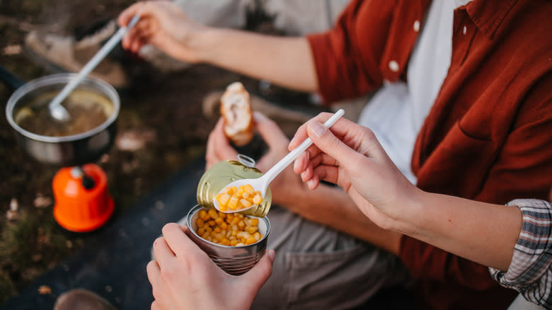 Campers eating canned corn from the can