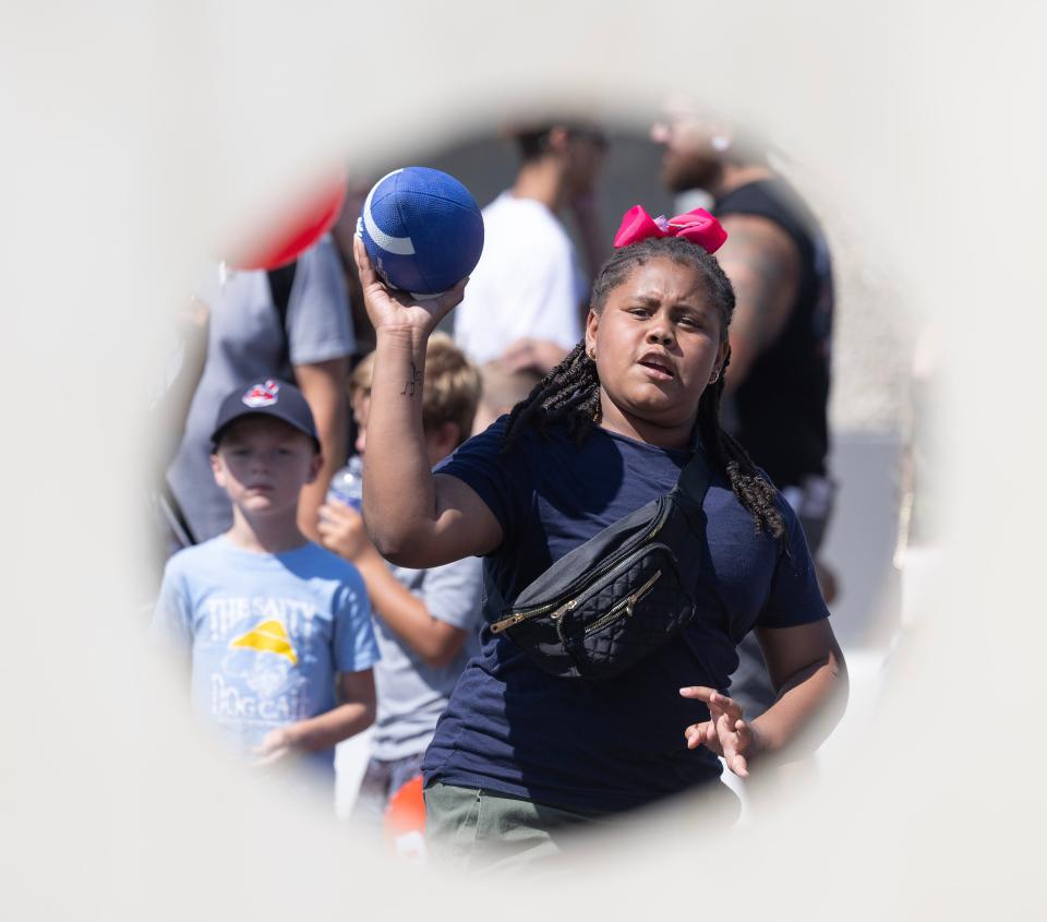 Dallis Jackson, 10, of North Canton tries her hand at the football toss at the Downtown Massillon Fun Fest.