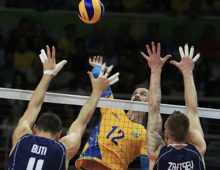 2016 Rio Olympics - Volleyball - Men's Gold Medal Match Italy v Brazil - Maracanazinho - Rio de Janeiro, Brazil - 21/08/2016. Lipe (BRA) of Brazil spikes as Simone Buti (ITA) of Italy and Ivan Zaytsev (ITA) of Italy block. REUTERS/Dominic Ebenbichler