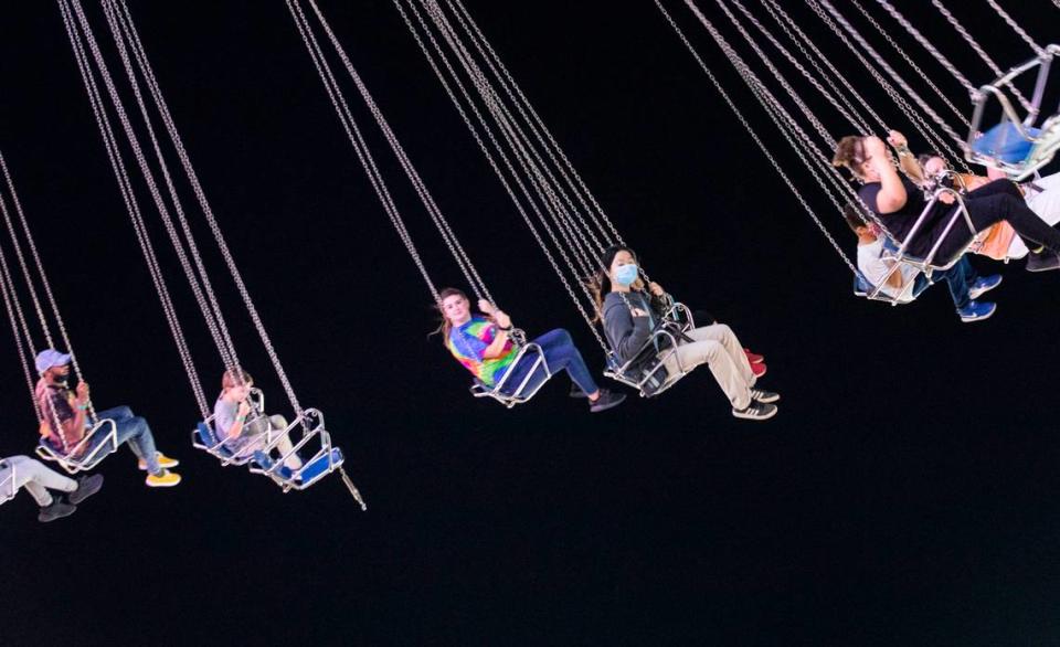 Patrons of the North Carolina State Fair in Raleigh, N.C. ride the “Wave Swinger” on opening night, Thursday, Oct. 14, 2021.