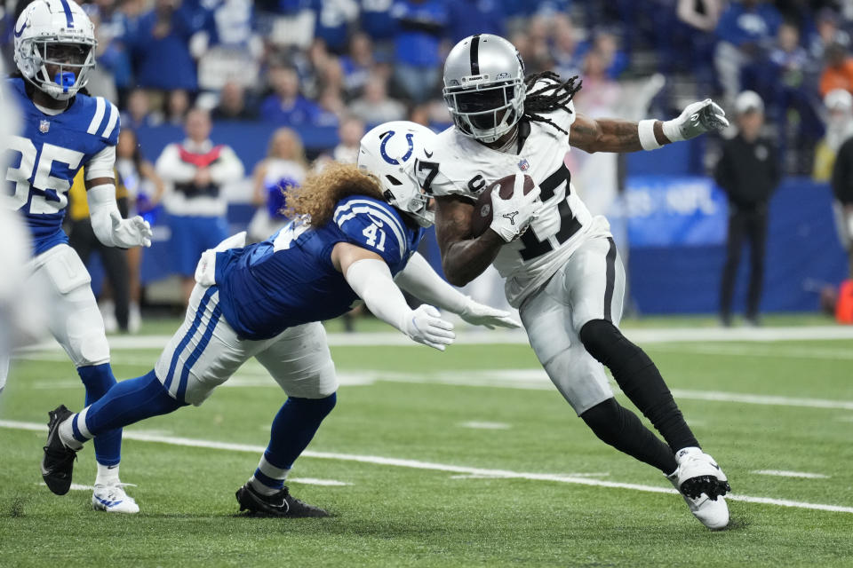 Las Vegas Raiders wide receiver Davante Adams (17) runs past Indianapolis Colts linebacker Grant Stuard (41) during the second half of an NFL football game Sunday, Dec. 31, 2023, in Indianapolis. (AP Photo/AJ Mast)