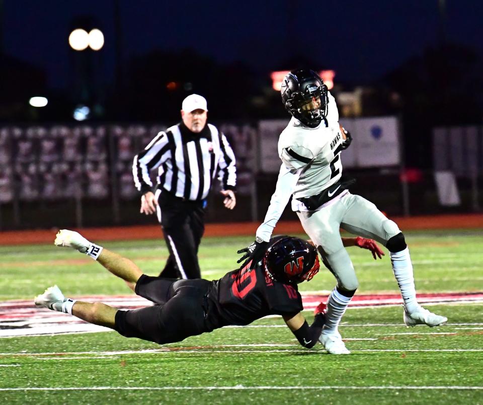 Lakota East's Caleb VanHooser (2) is tripped up by Silas Walters (10) of Lakota West in second-round OHSAA Division I playoff action, Oct. 16. 2020.
