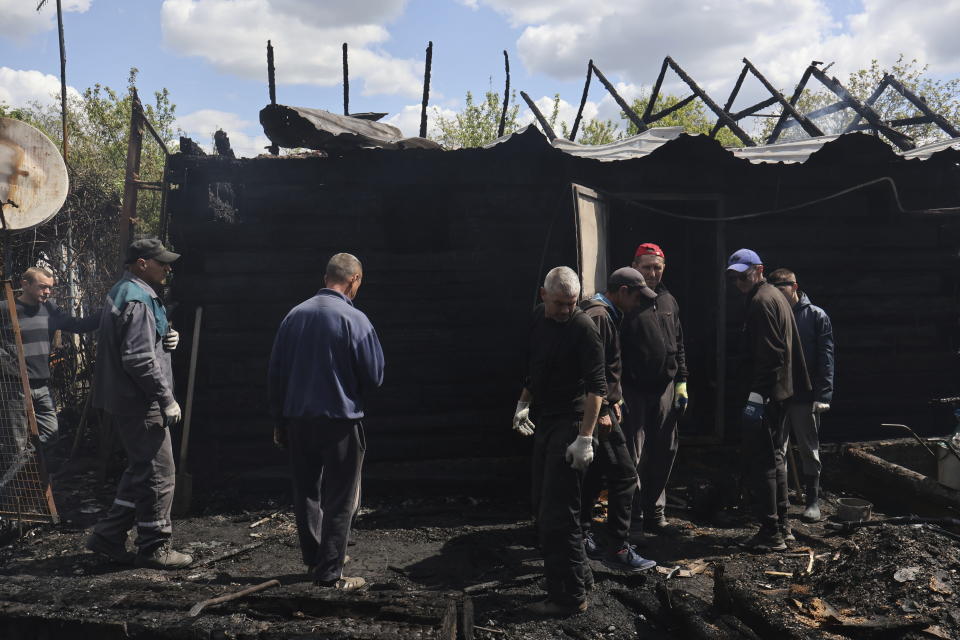 Local residents stand next to a private house that was damaged in the night, following Russian shelling in Malokaterinivka, Zaporizhzhia region, Ukraine, Thursday, May 11, 2023. (AP Photo/Andriy Andriyenko)