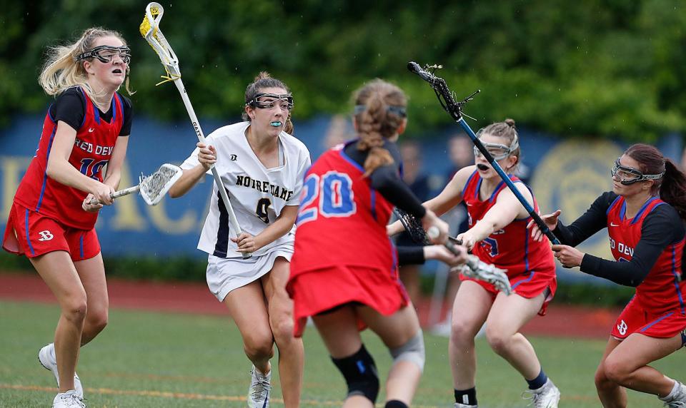 Midfielder Jane Hilsabeck gets surrounded by Burlington players.Notre Dame Academy Hingham hosted Burlington in MIAA playoff action in Hingham on Friday June 9, 2023 