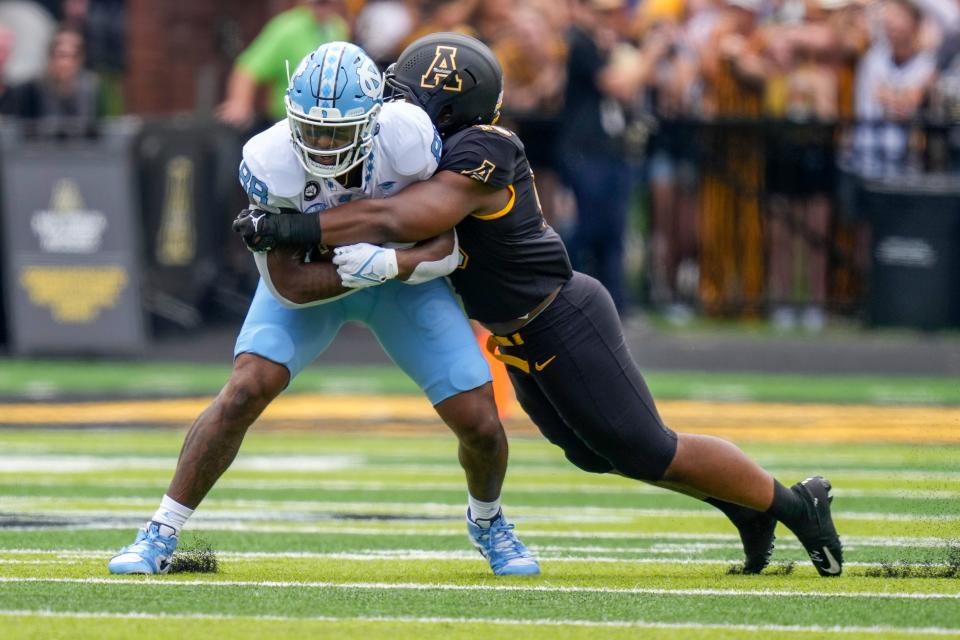 Sep 3, 2022; Boone, North Carolina, USA; North Carolina Tar Heels tight end Kamari Morales (88) is tackled by Appalachian State Mountaineers linebacker Andrew Parker (15) during the first quarter at Kidd Brewer Stadium. Mandatory Credit: Jim Dedmon-USA TODAY Sports