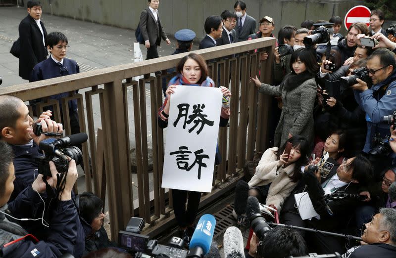 Japanese journalist Shiori Ito holds a banner reading "Victory" outside the Tokyo District Court after a court verdict ordered in Tokyo