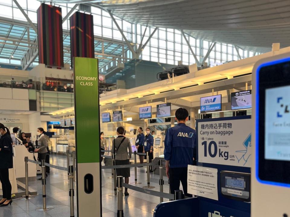 A green sign for the economy line at ANA's check-in counter at Haneda Terminal 3.