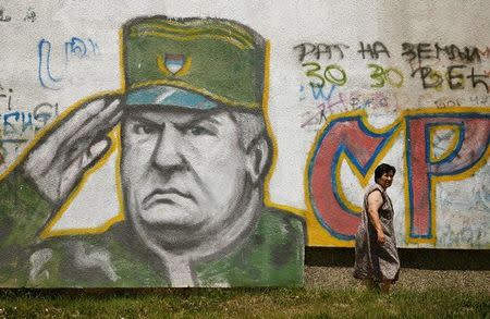 FILE PHOTO: A woman walks past a mural of Bosnian Serb wartime general Ratko Mladic in Belgrade, Serbia June 11, 2009. REUTERS/Marko Djurica/File Photo