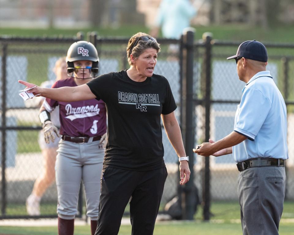 Round Rock softball coach Jennifer Painter discusses a call at third base with an umpire during a 2023 area-round playoff game against Schertz Clemens, which the Dragons won 2-0.