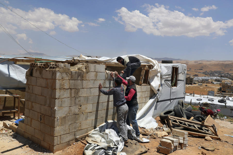 In this Sunday, June 16, 2019 photo, Syrian refugees demolish a concrete wall built inside their tent at a refugee camp in the eastern Lebanese border town of Arsal, Lebanon. Authorities in Lebanon are waging their most aggressive campaign yet against Syrian refugees, making heated calls for them to go back to their country and taking action to ensure they can’t put down roots. They are shutting down shops where Syrians work without permits and ordering the demolition of anything in their squalid camps that could be a permanent home. (AP Photo/Bilal Hussein)