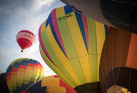 <p>Hot air balloons are inflated and take to the skies as they participate in the mass assent at sunrise in the main arena on the second day of the Bristol International Balloon Fiesta on August 11, 2017 in Bristol, England. (Photo: Matt Cardy/Getty Images) </p>