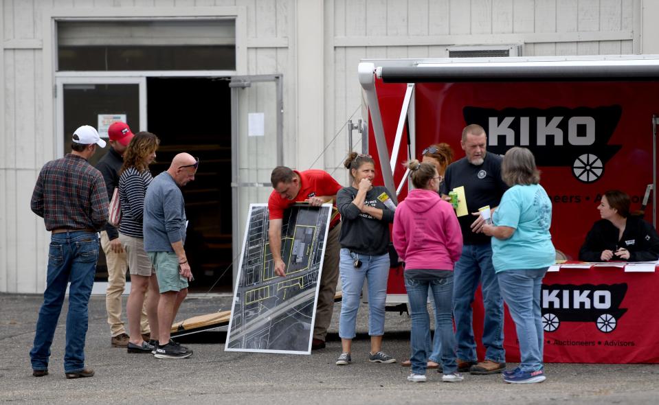 Onlookers gather Monday at the Discount Outlet store site in northeast Massillon prior to a property auction. The main store building and multiple parcels of land were sold.