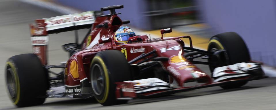 Ferrari Formula One driver Fernando Alonso of Spain takes a corner during the first practice session of Singapore F1 Grand Prix on the Marina Bay street circuit in Singapore September 19, 2014. REUTERS/Tim Chong (SINGAPORE - Tags: SPORT MOTORSPORT F1)