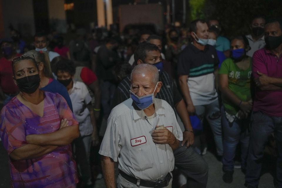 Voters line up during an election re-run to decide the governor in Barinas, Venezuela, Sunday, Jan. 9, 2022. Resident of the home state of the late Venezuelan President Hugo Chávez are voting again Sunday in a special gubernatorial election called after the opposition contender in November’s regular contest was retroactively disqualified as he was ahead in the vote count. (AP Photo/Matias Delacroix)