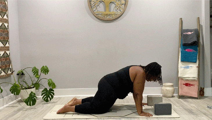 Woman on hands and knees on her yoga mat doing hip circles