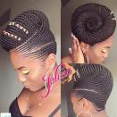 St. Kitts–based hairstylist <span>Jalicia</span> created this gorgeous updo, which she punctuated with a bit of colorful thread in the front. While we're sure the braids she twisted into a giant bun look great when they are hanging loose, we're obsessed with the drama this swirly updo is serving.