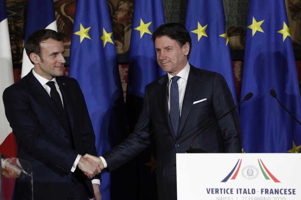 Italian Premier Giuseppe Conte, right, and French President Emmanuel Macron shake hands after a press conference on the occasion of the first French-Italian summit in more than two years, in Naples, southern Italy, Thursday, Feb. 27, 2020. (AP Photo/Andrew Medichini)