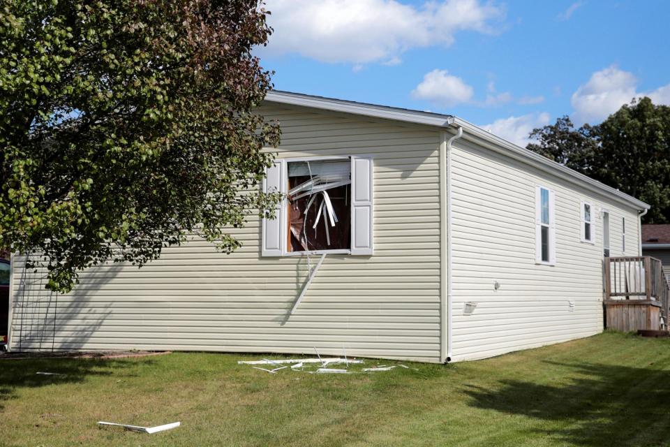 A broken front window was seen at a home after being searched by FBI agents for alleged plots to take the Democratic Governor Gretchen Whitmer hostage and attack the state capitol building(REUTERS)