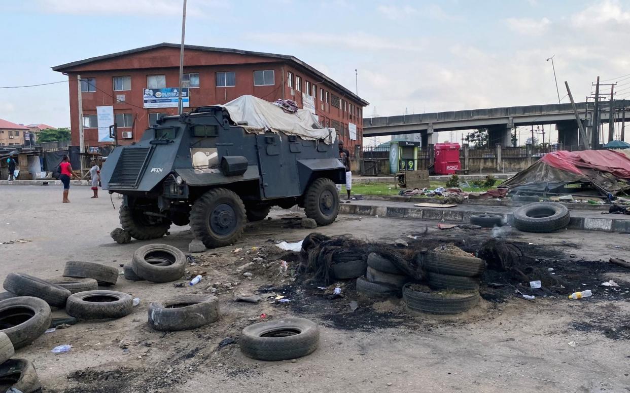 A police vehicle stands at a burned down checkpoint in Lagos - SEUN SANNI /REUTERS