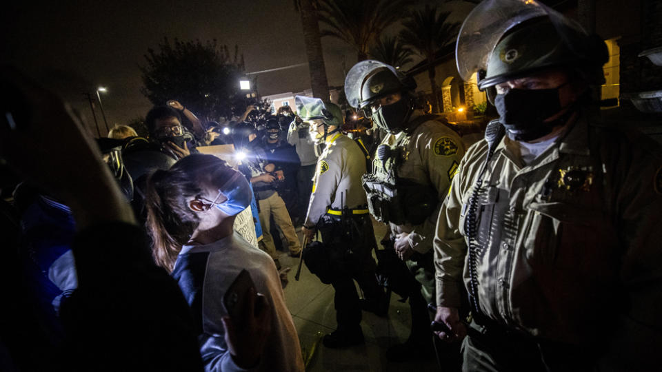 Protesters face off with sheriff deputies standing guard in front of the Westmont Sheriff Station following the death of Dijon Kizzee