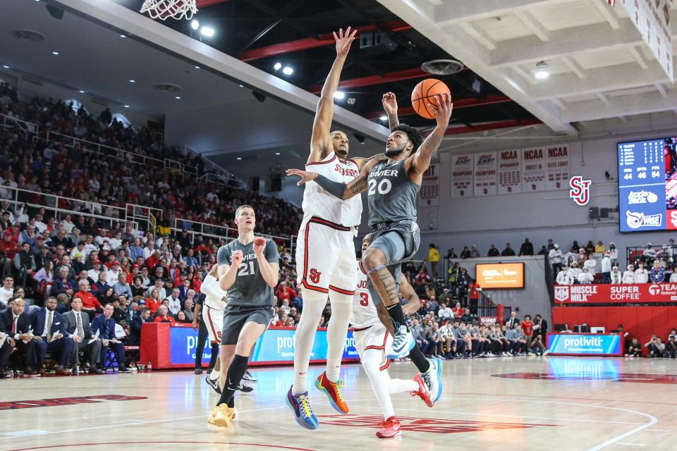 Dec 20, 2023; Queens, New York, USA; Xavier Musketeers guard Dayvion McKnight (20) drives past St. John's Red Storm center Joel Soriano (11) in the first half at Carnesecca Arena.