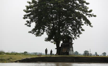 India's Border Security Force (BSF) soldiers stand guard at the international border between India and Bangladesh at Patamari village in Dhubri district, in the northeastern state of Assam, India August 4, 2018. REUTERS/Adnan Abidi