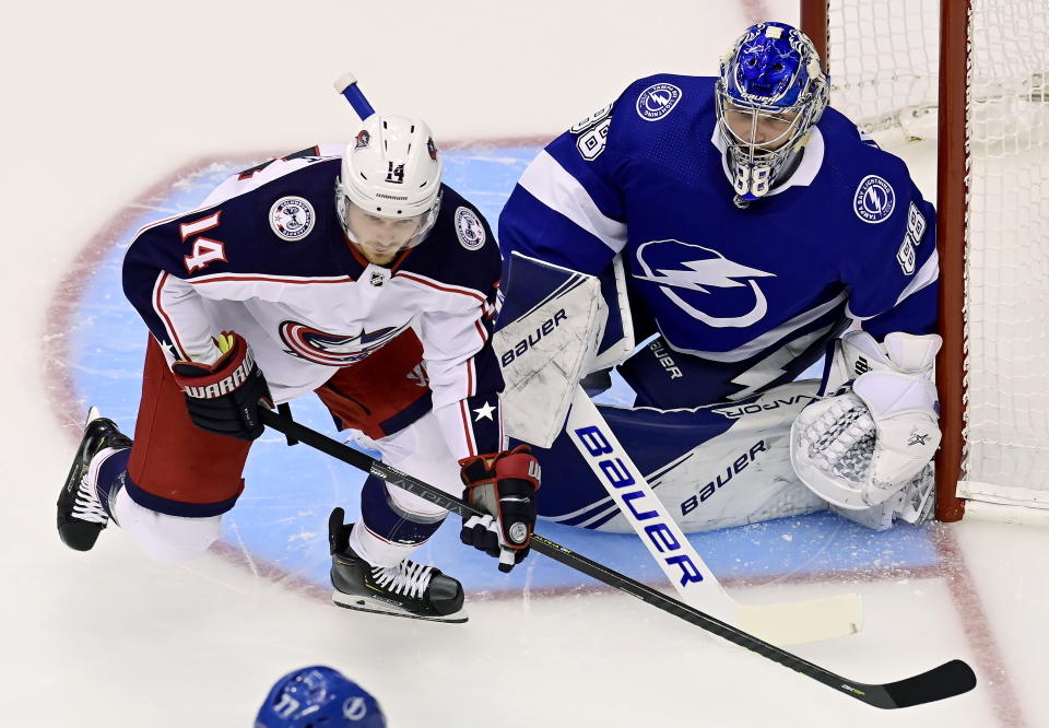 Columbus Blue Jackets center Gustav Nyquist (14) looks for the puck as Tampa Bay Lightning goaltender Andrei Vasilevskiy (88) defends the net during the first period of an NHL hockey Stanley Cup playoff gsme in Toronto, Thursday, Aug. 13, 2020. (Frank Gunn/The Canadian Press via AP)